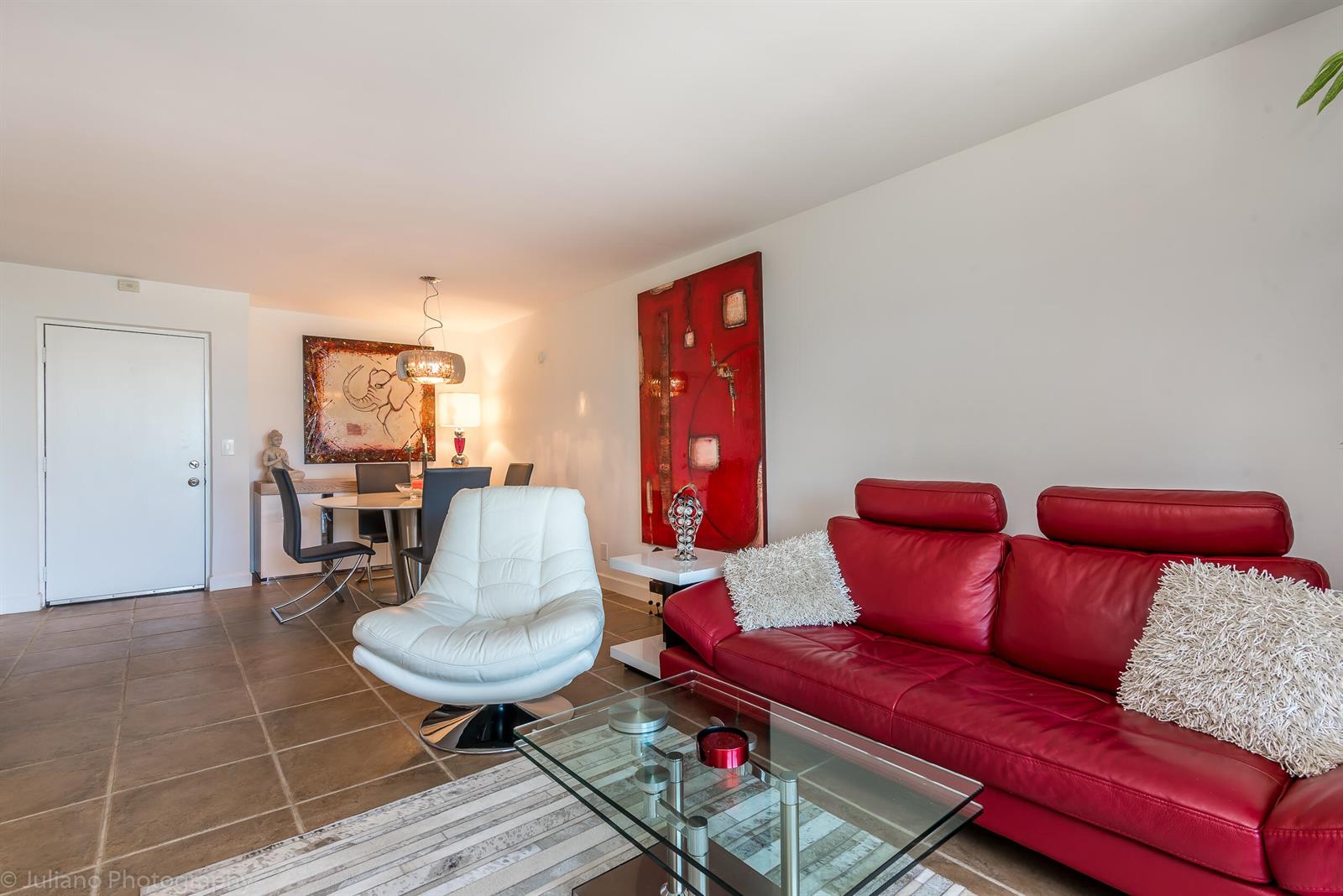 A living and dining area features a red leather sofa, white chair, and tile flooring — 2255 Lindell Boulevard # 4306, Delray Beach FL 33444, DELRAY BEACH, FL