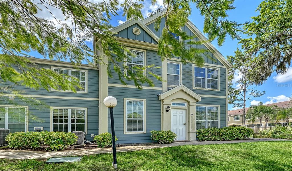 A two-story blue house with white trim and a front entrance under a small portico — 5501 ROSEHILL ROAD UNIT 105, SARASOTA, FL