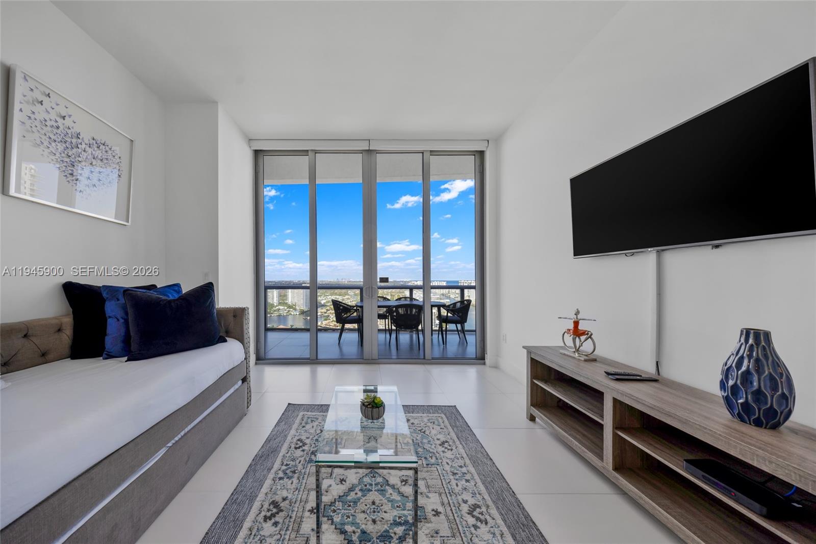 A modern living room features a daybed, glass coffee table, and balcony with water views — 2600 E Hallandale Beach Blvd # T3304, Hallandale Beach FL 33009, HALLANDALE BEACH, FL