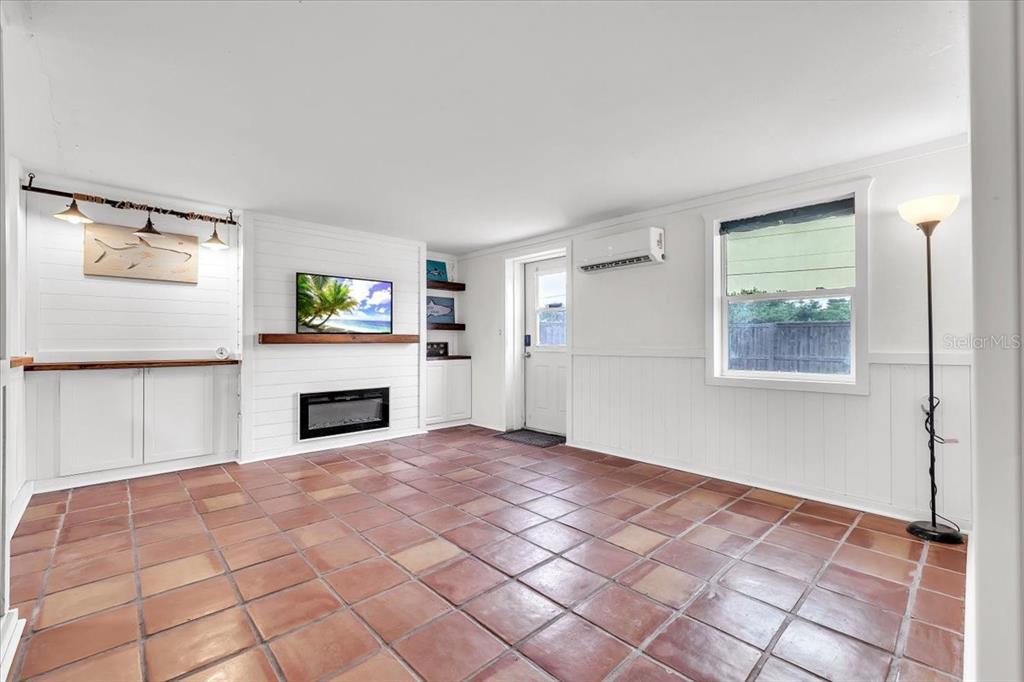 A living room features terracotta tile floors, white shiplap walls, a fireplace, and nautical decor — 1144 PINE STREET, ENGLEWOOD, FL