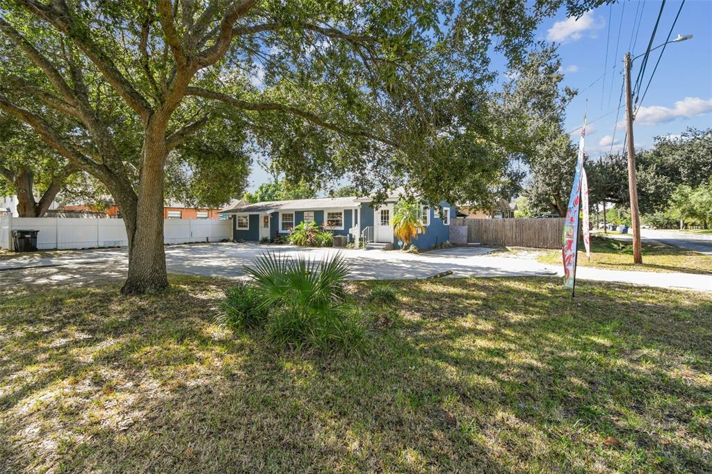 A blue single-story building with a large paved parking area and mature trees — 9912 N MYRTLE STREET, TAMPA, FL