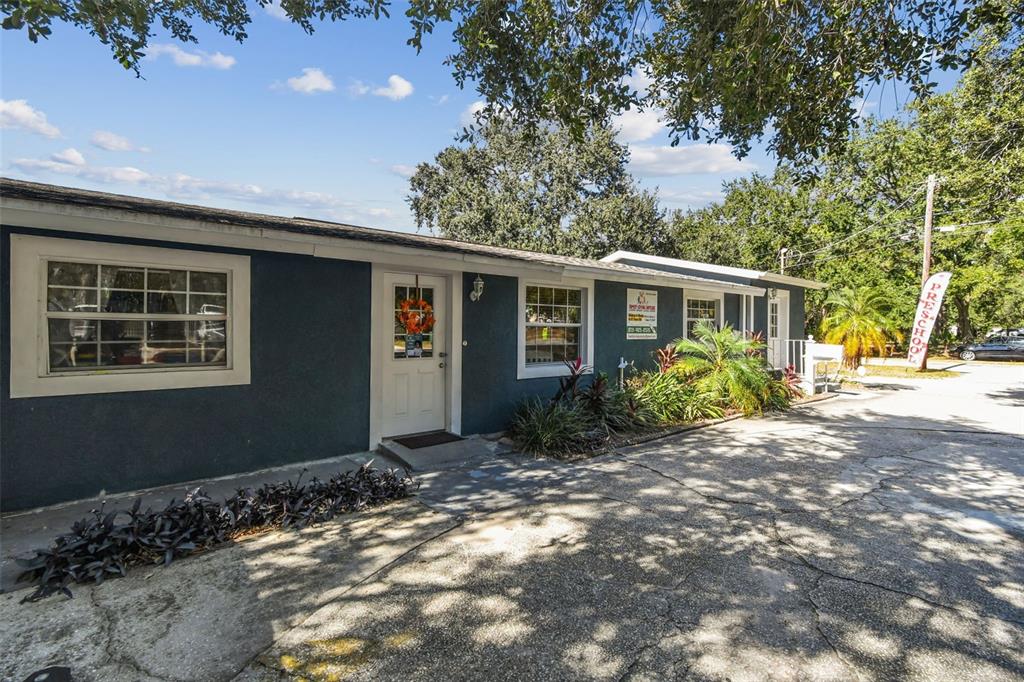 A dark blue, single-story commercial building with a white door and a preschool sign — 9912 N MYRTLE STREET, TAMPA, FL