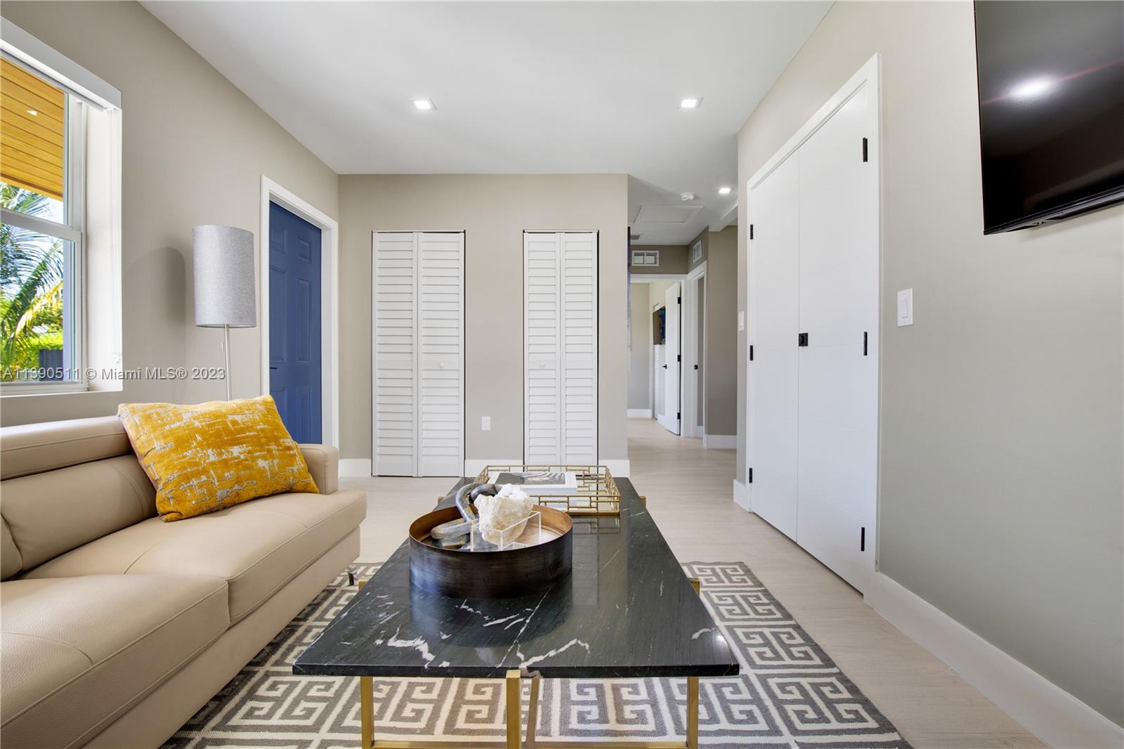 A living room features a beige sofa, a black marble coffee table, and white doors — 6428 SW 23rd St # 6428, Miami FL 33155, MIAMI, FL
