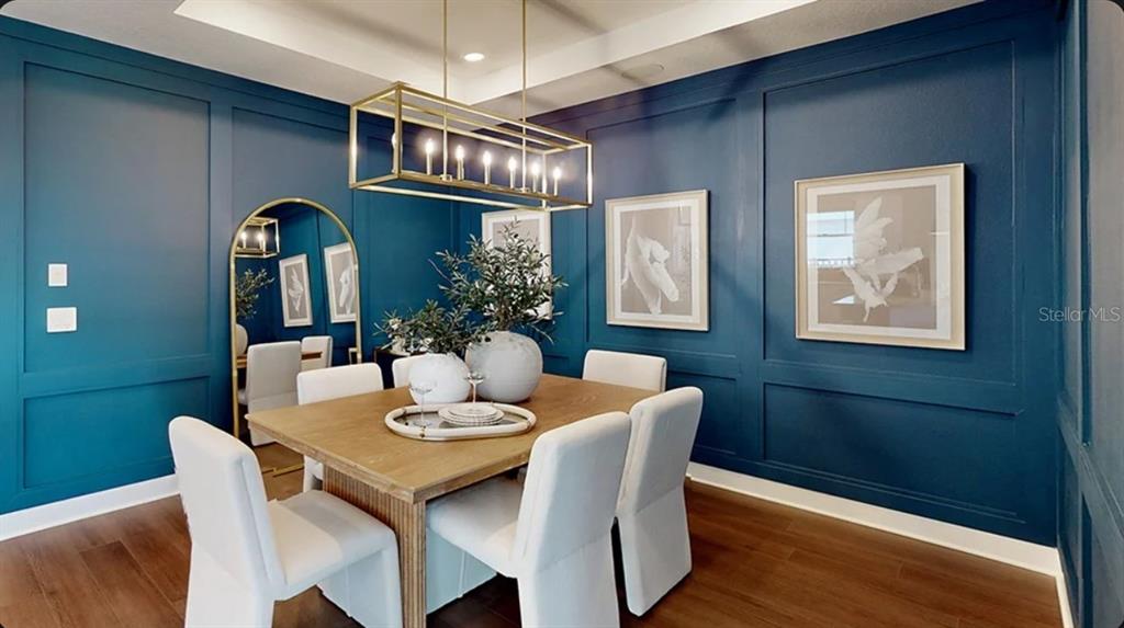 A dining room features blue paneled walls, a rectangular gold chandelier, and a wooden table — 11291 SILVER TRUMPET LOOP, WINTER GARDEN, FL