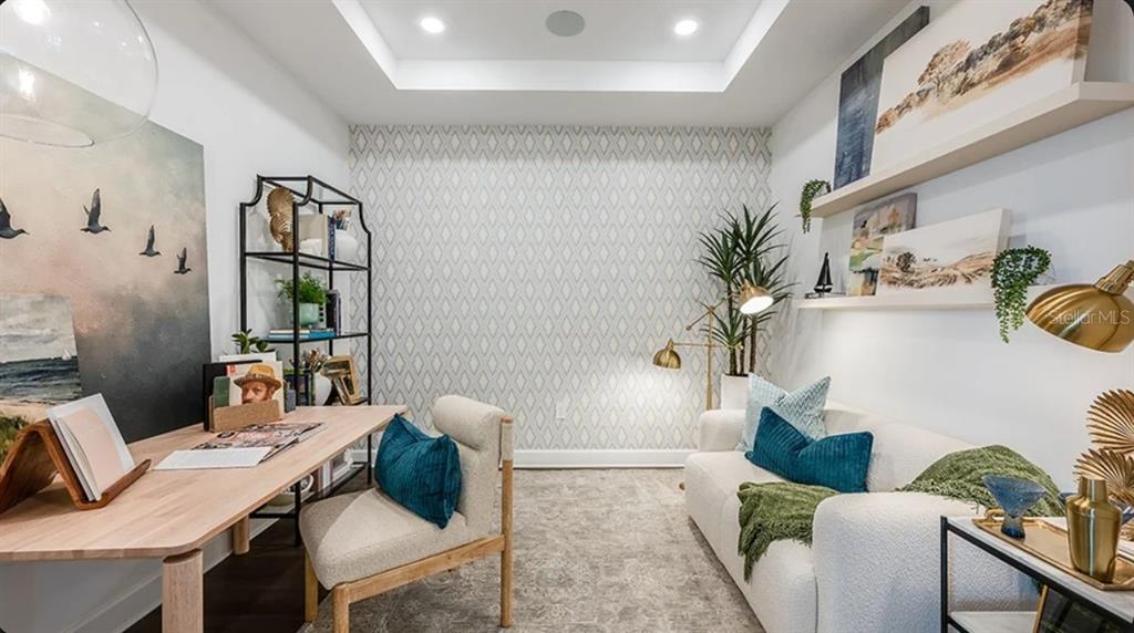A home office features a desk, a sofa, patterned wallpaper, and floating shelves — 11291 SILVER TRUMPET LOOP, WINTER GARDEN, FL