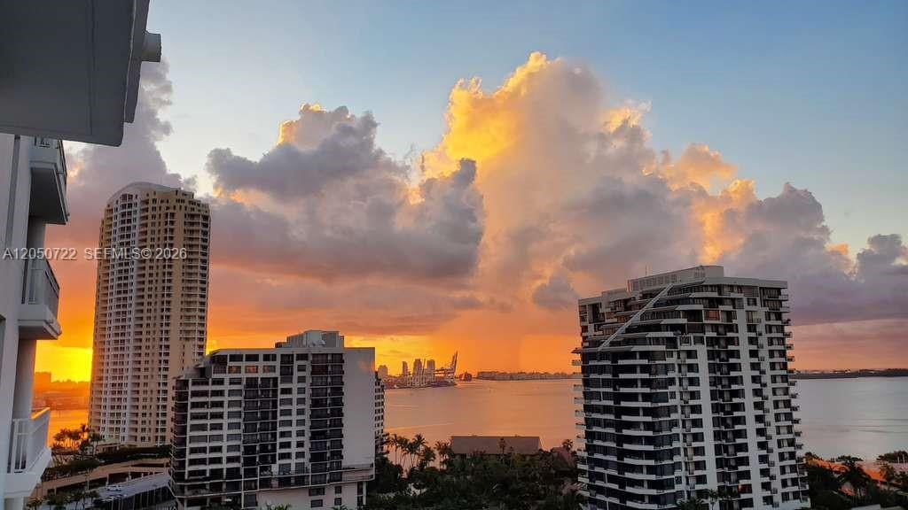 A view of high-rise buildings and a body of water under a dramatic sunset sky — 701 Brickell Key Blvd # 1611, Miami FL 33131, MIAMI, FL