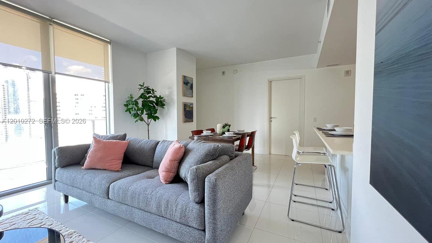 A living room features a gray sofa, a dining area, and a breakfast bar — 1300 Brickell Bay Dr # 3400, Miami FL 33131, MIAMI, FL
