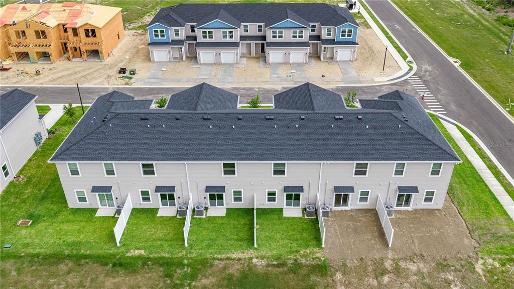 An aerial view shows two multi-unit townhome buildings, one completed and one under construction — 4969 SW 83RD PLACE, OCALA, FL