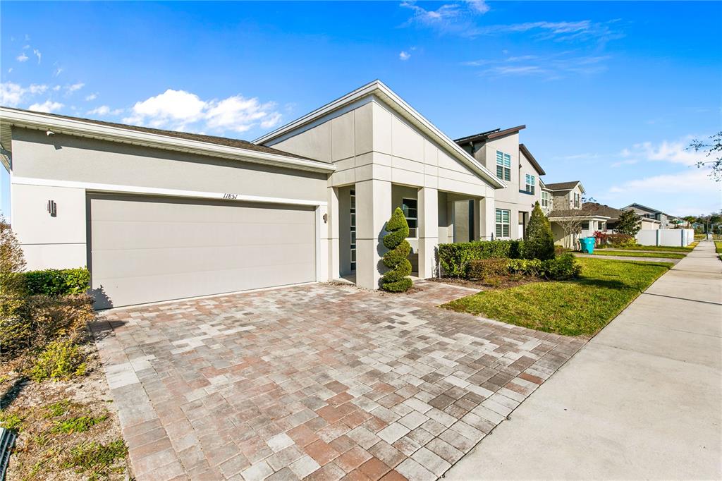A modern single-story house features a paved driveway, a two-car garage, and a covered entryway — 11851 SUNSAIL AVENUE, ORLANDO, FL