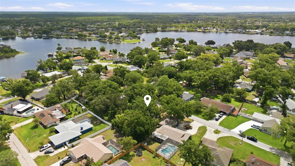 An aerial view shows a residential neighborhood with houses, trees, and a lake — 3651 GREATWOOD COURT, LAND O LAKES, FL