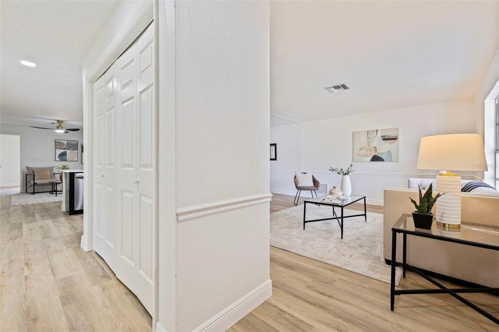 A view from a hallway looking into a living room with light wood-look flooring — 3651 GREATWOOD COURT, LAND O LAKES, FL