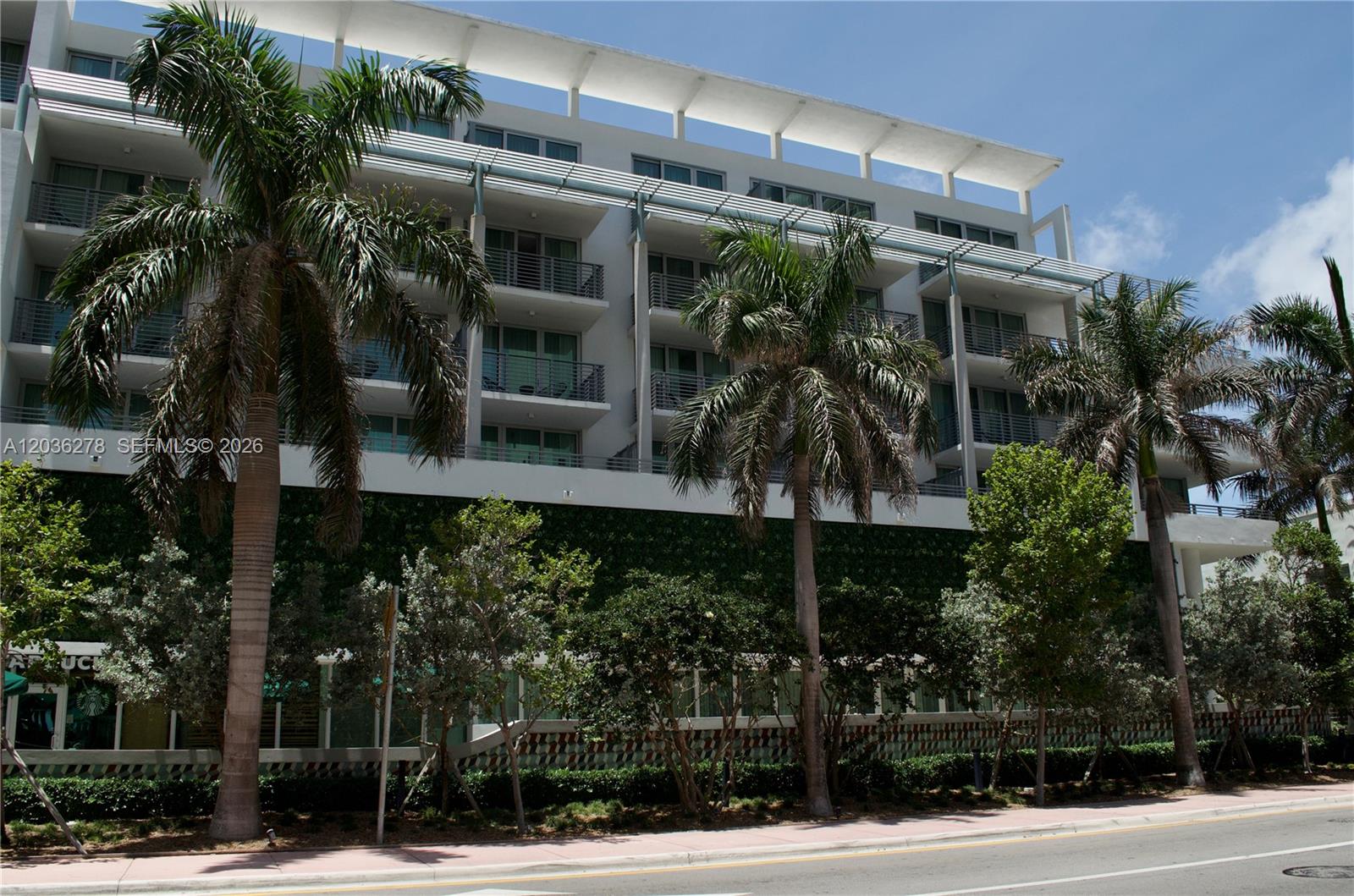 A multi-story building with balconies and palm trees stands along a street — 6080 Collins Ave # 506, Miami Beach FL 33140, MIAMI BEACH, FL