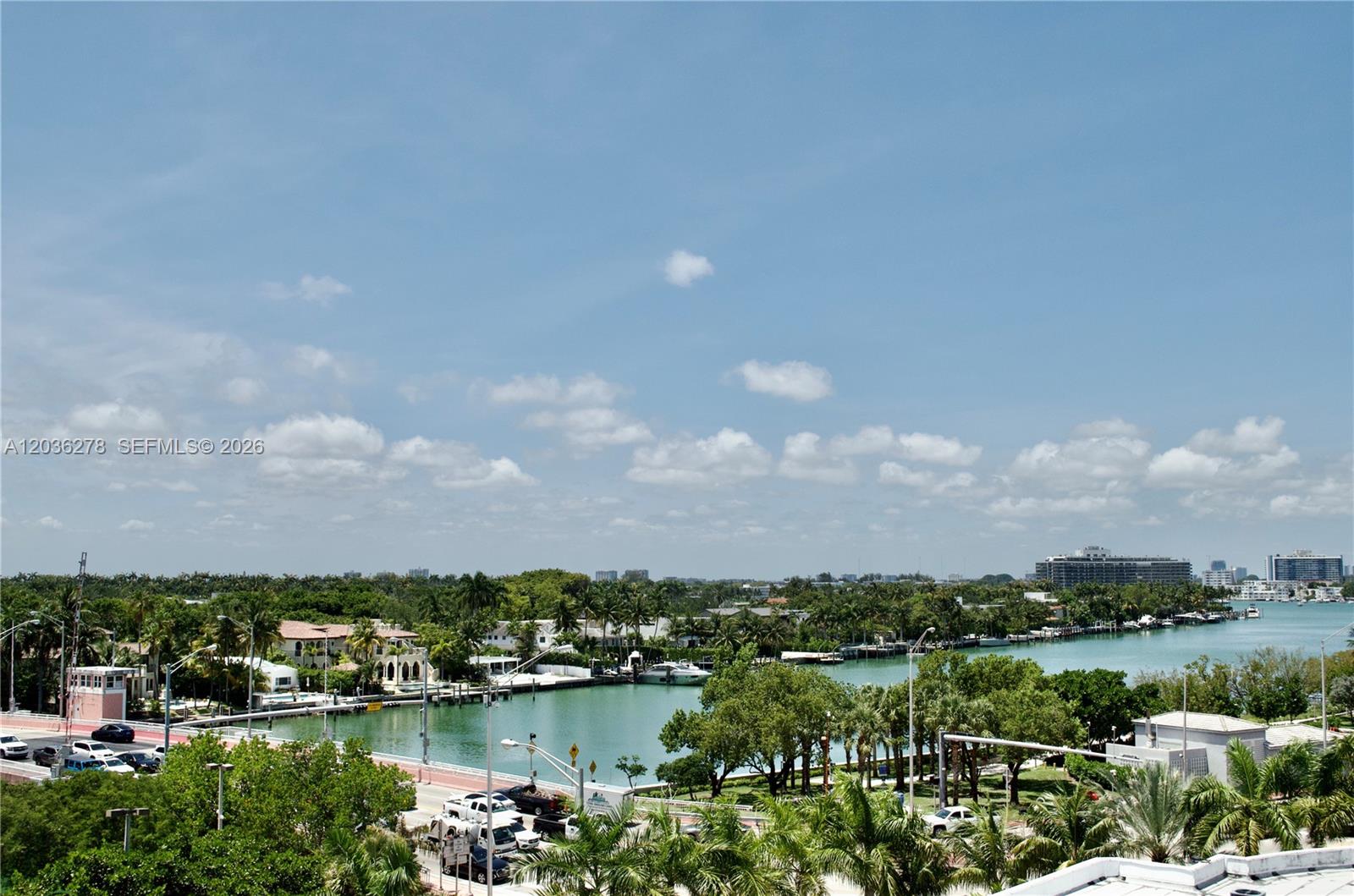 An elevated view shows a waterway lined with houses, palm trees, and parked cars — 6080 Collins Ave # 506, Miami Beach FL 33140, MIAMI BEACH, FL