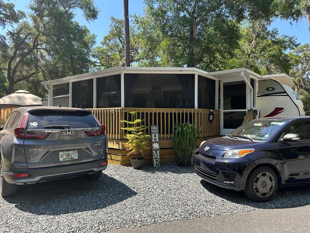 An illuminated wooden deck with a screened-in porch and an American flag at night — 25208 NE 143RD STREET, SALT SPRINGS, FL