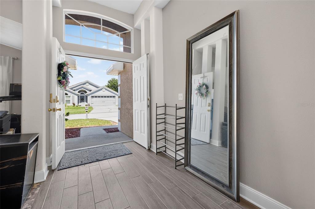 A tan single-story house with a two-car garage and a large front lawn — 264 LAUREL RIDGE PASS, DAVENPORT, FL