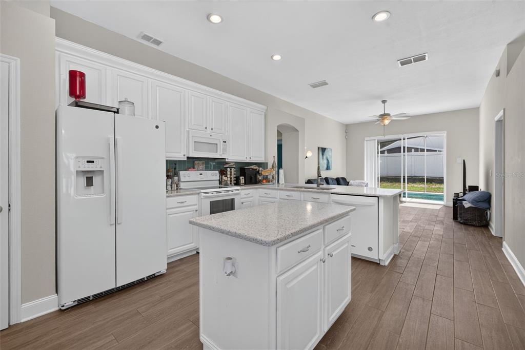 An entryway with wood-look tile flooring, a large floor mirror, and an open front door — 264 LAUREL RIDGE PASS, DAVENPORT, FL