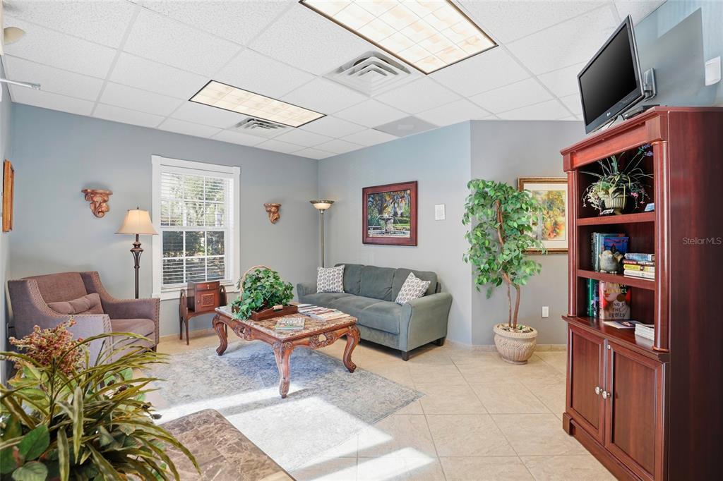 A waiting room features a gray sofa, an armchair, a coffee table, and tiled flooring — 4130 NW 37TH PLACE Ste E, GAINESVILLE, FL