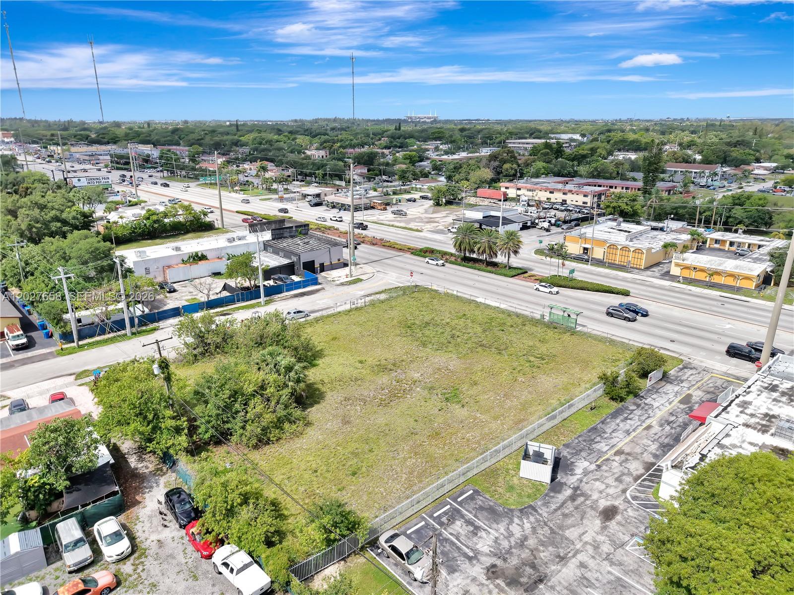 An aerial view shows a vacant, fenced-in grass lot situated next to a busy road — 2591 S State Road 7 Rd, West Park FL 33023, WEST PARK, FL