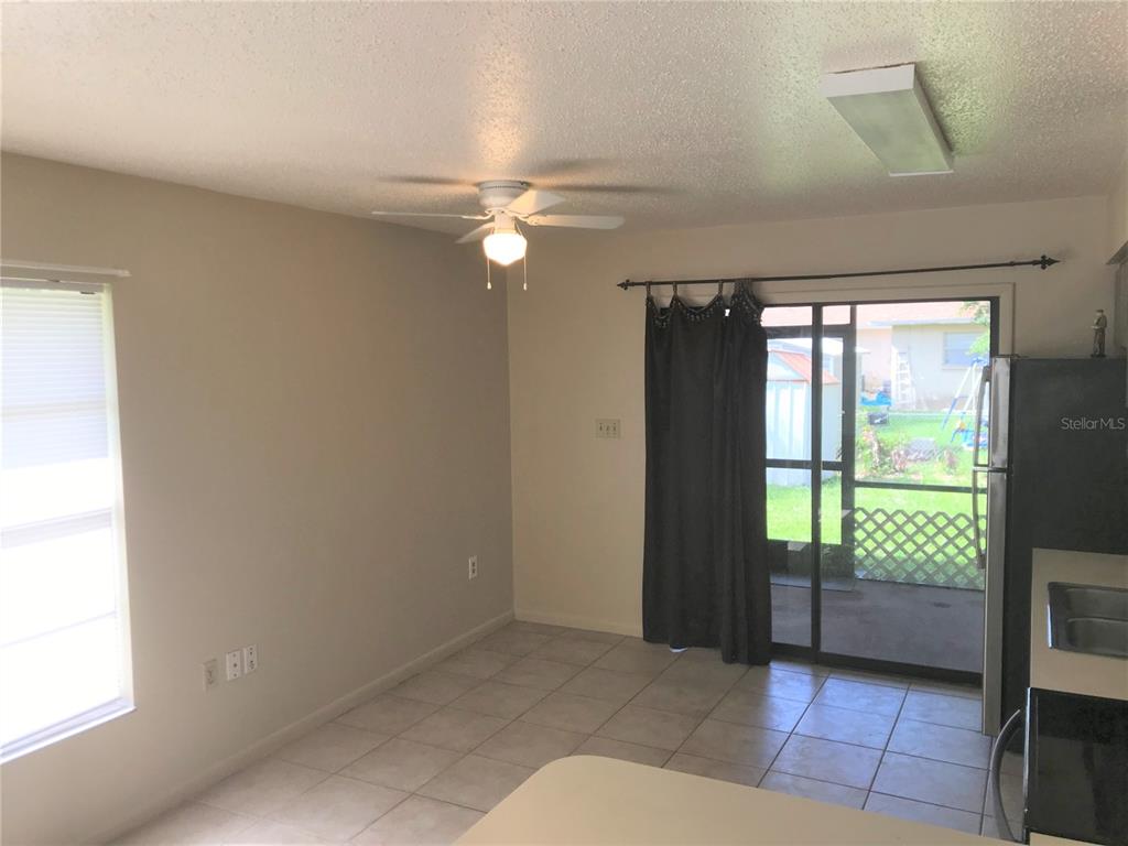 A dining area with tile floors, a ceiling fan, and a sliding door to a patio — 2806 46TH AVENUE DRIVE W, BRADENTON, FL