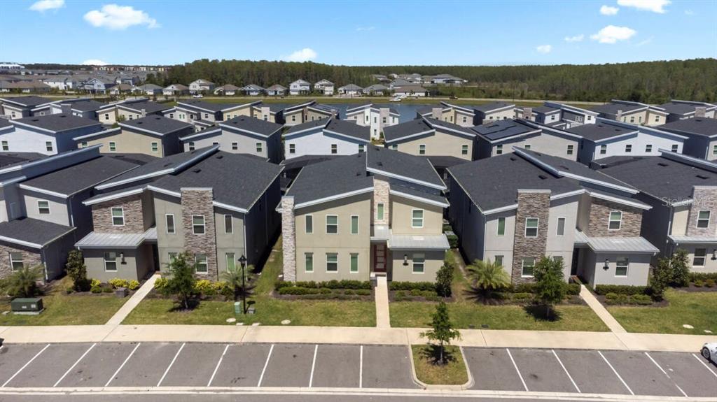 An aerial view shows a row of modern two-story townhomes with parking spaces in front — 4525 TARGET BOULEVARD, KISSIMMEE, FL