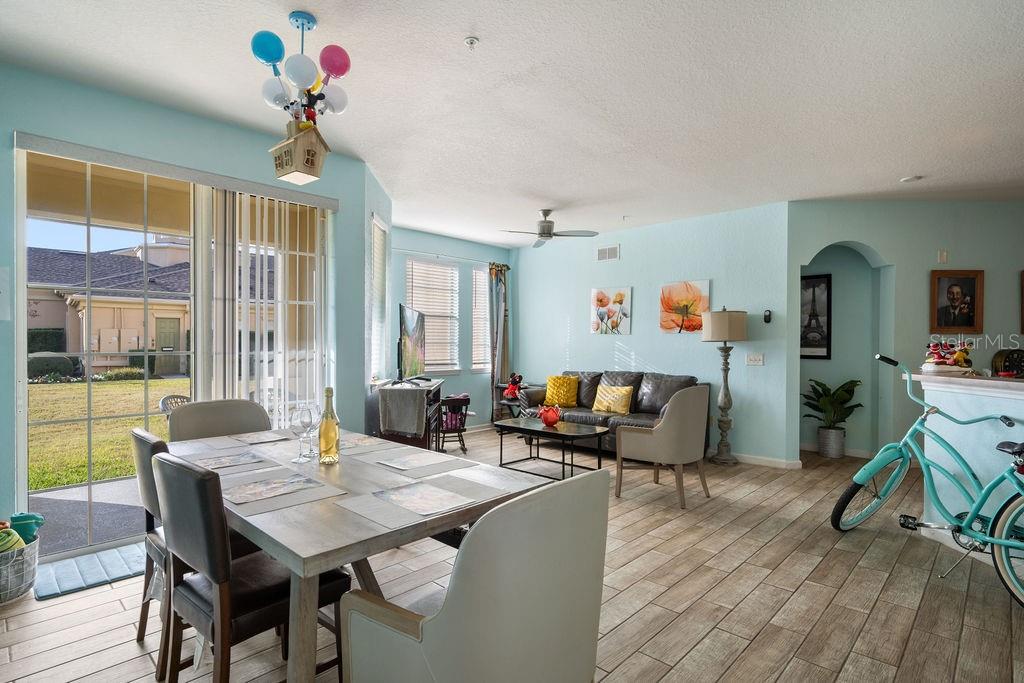A dining and living area features light blue walls, tile flooring, and a balloon-themed chandelier — 302 TERRACE RIDGE CIRCLE UNIT 302, DAVENPORT, FL