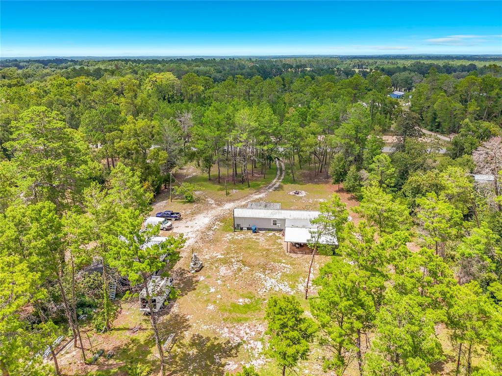 A single-story house with a metal roof and front porch sits on a grassy lot — 151 LAKE SUSAN ROAD, HAWTHORNE, FL