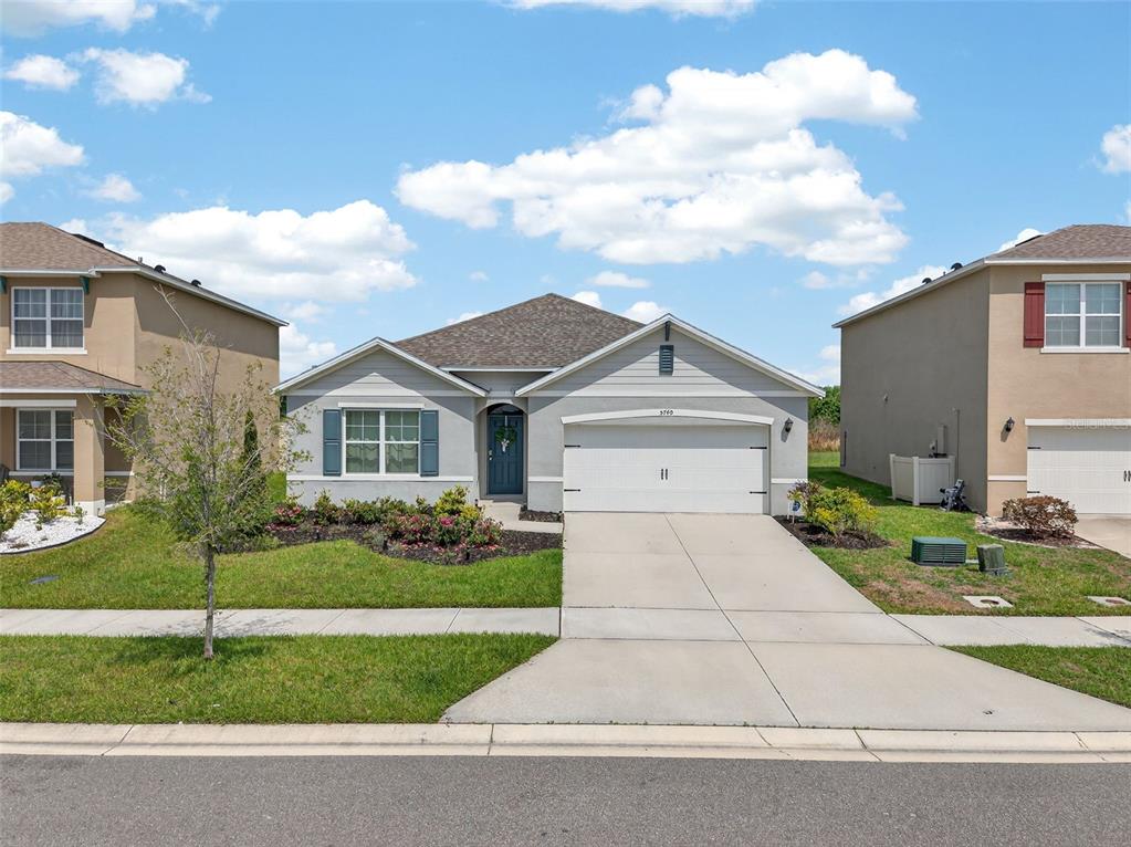 A single-story suburban house with a gray exterior, a two-car garage, and a front lawn — 5740 GREY GRANITE WAY, LAKELAND, FL