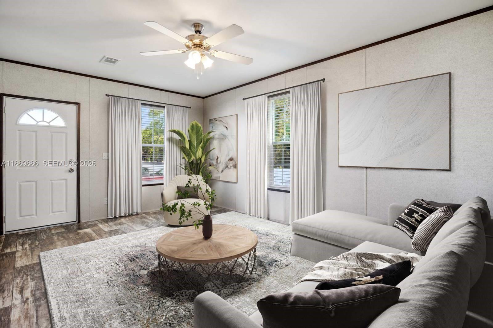 This living room features a sectional sofa, a round coffee table, and two windows — 357 Horse Club, Clewiston FL 33440, CLEWISTON, FL