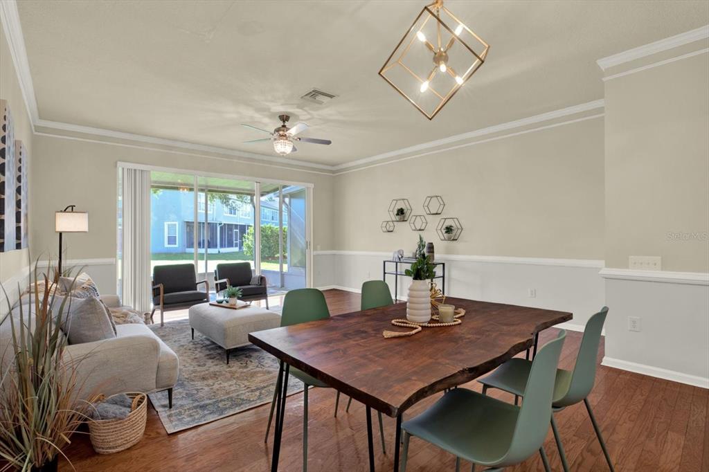 A dining area and living room with wood floors, a live-edge table, and sliding doors — 2733 CONCH HOLLOW DRIVE, BRANDON, FL