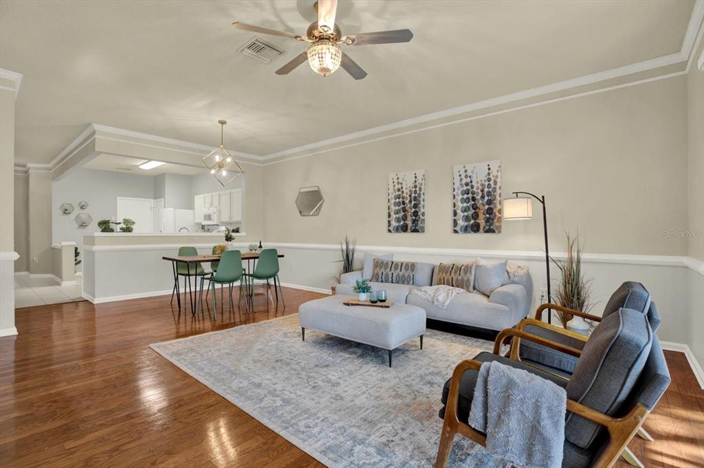 A living room and dining area with hardwood floors, a ceiling fan, and neutral walls — 2733 CONCH HOLLOW DRIVE, BRANDON, FL