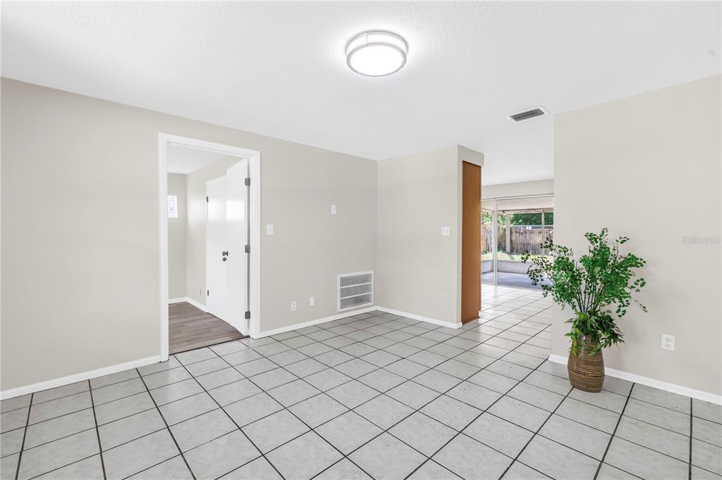 A room with light gray walls, tiled flooring, a ceiling light, and an open doorway — 10920 111TH STREET, LARGO, FL