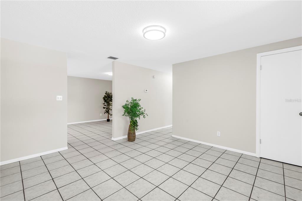A room with light gray walls, white trim, and light-colored square floor tiles — 10920 111TH STREET, LARGO, FL