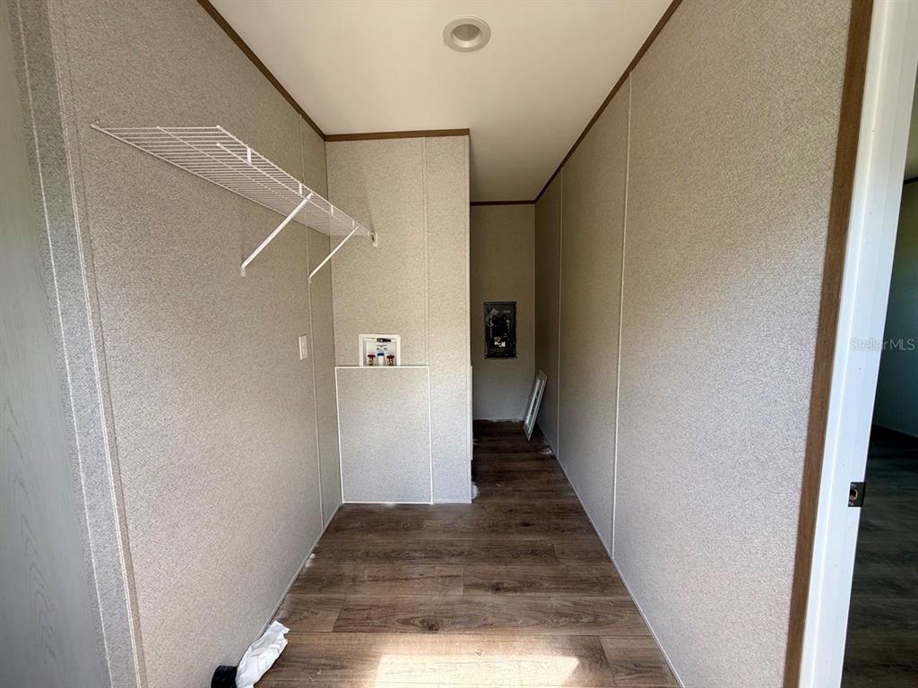 A laundry room features wood-look flooring, a wire shelf, and washer and dryer hookups — TBD NE 115TH AVENUE, WILLISTON, FL