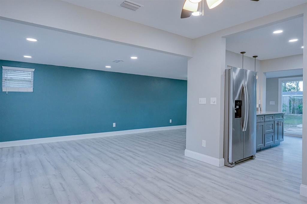 A view of a living area with a teal accent wall and an adjacent kitchen — 5135 NEWTON AVENUE S, GULFPORT, FL