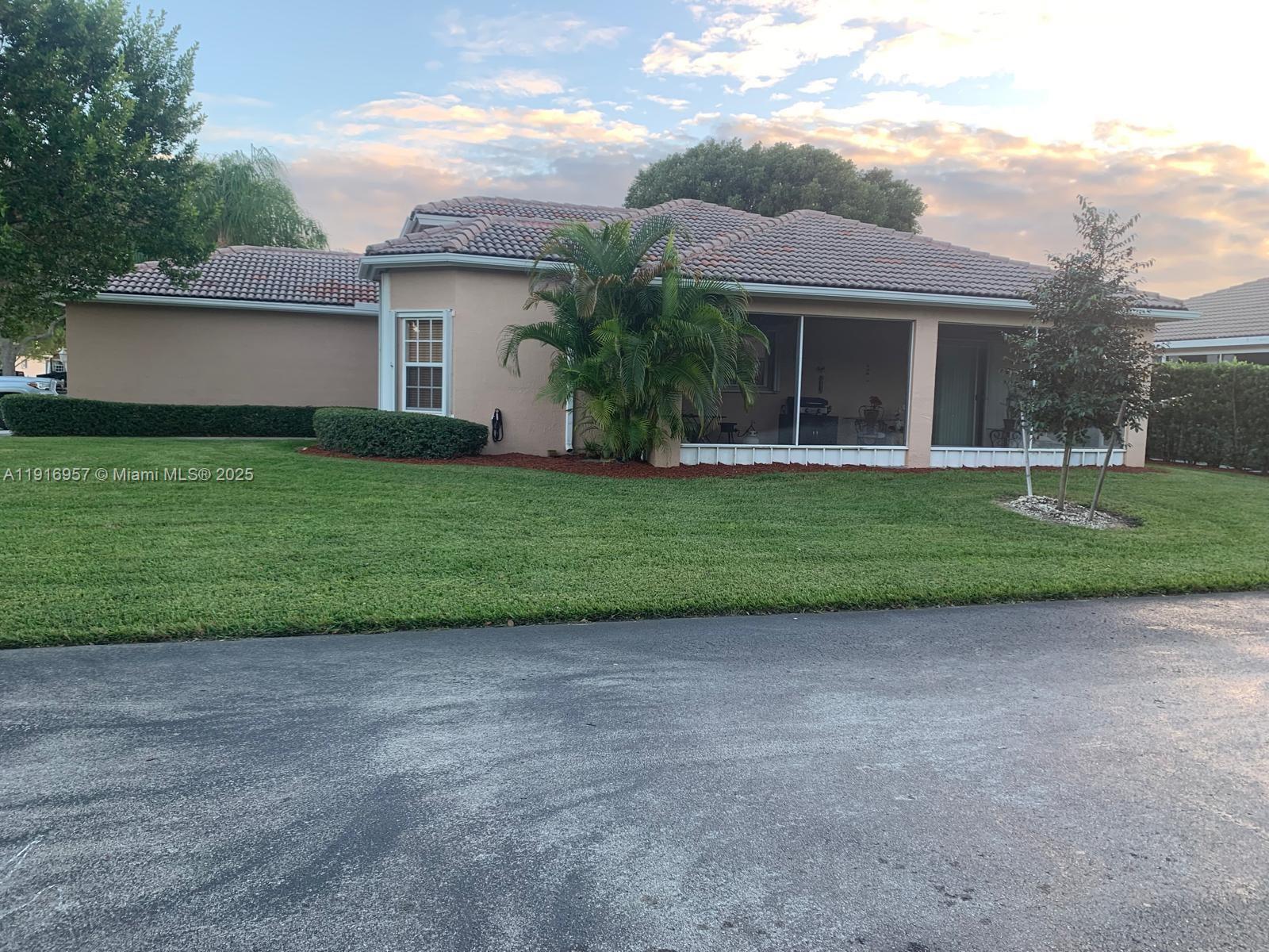 A single-story beige house with a tiled roof and a screened-in patio — 462 SE 23rd Dr, Homestead FL 33033, HOMESTEAD, FL