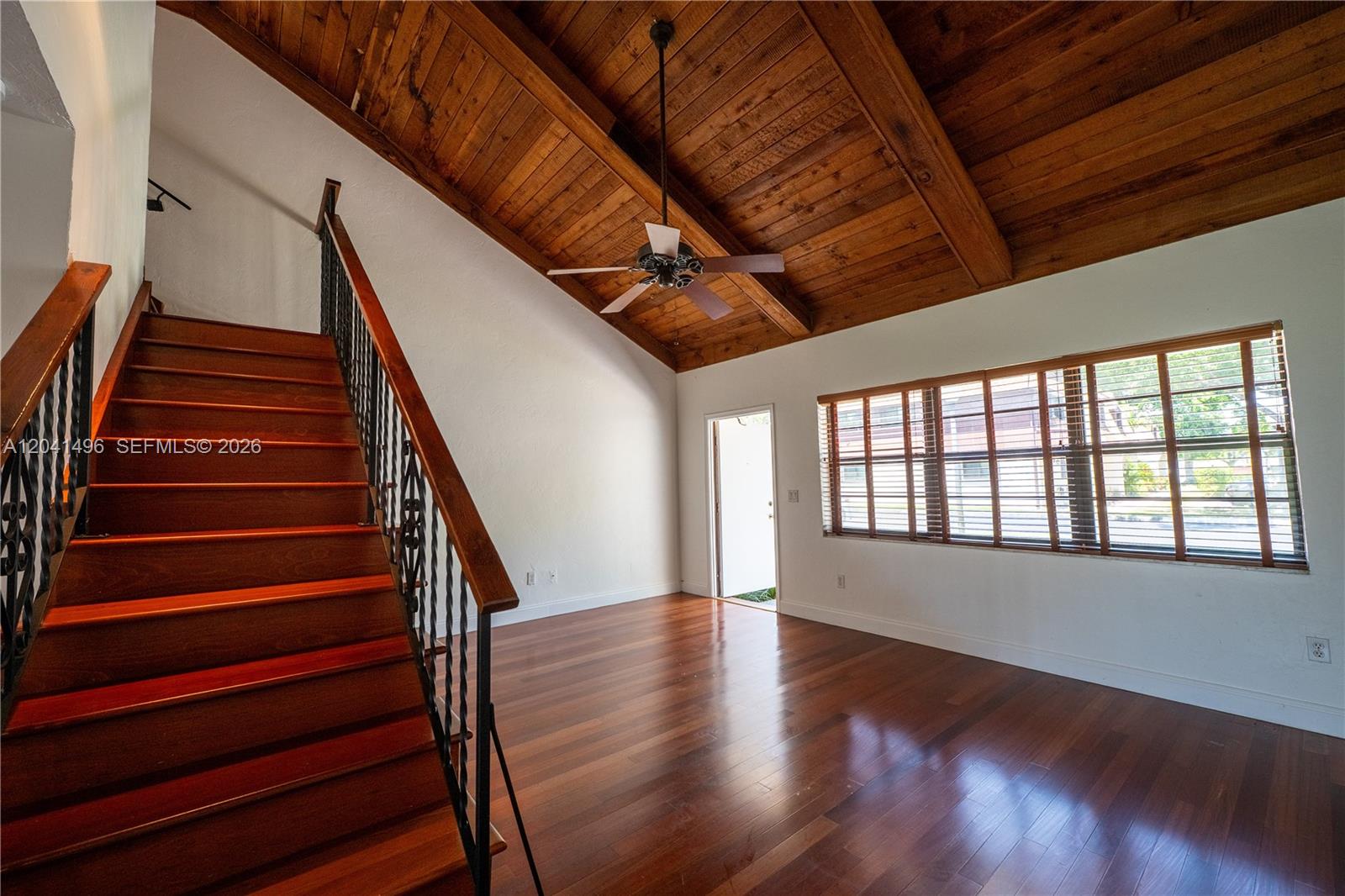 A room with wood flooring, a vaulted wood-paneled ceiling, and a staircase with metal railings — 2133 N 14th Ave, Hollywood FL 33020, HOLLYWOOD, FL