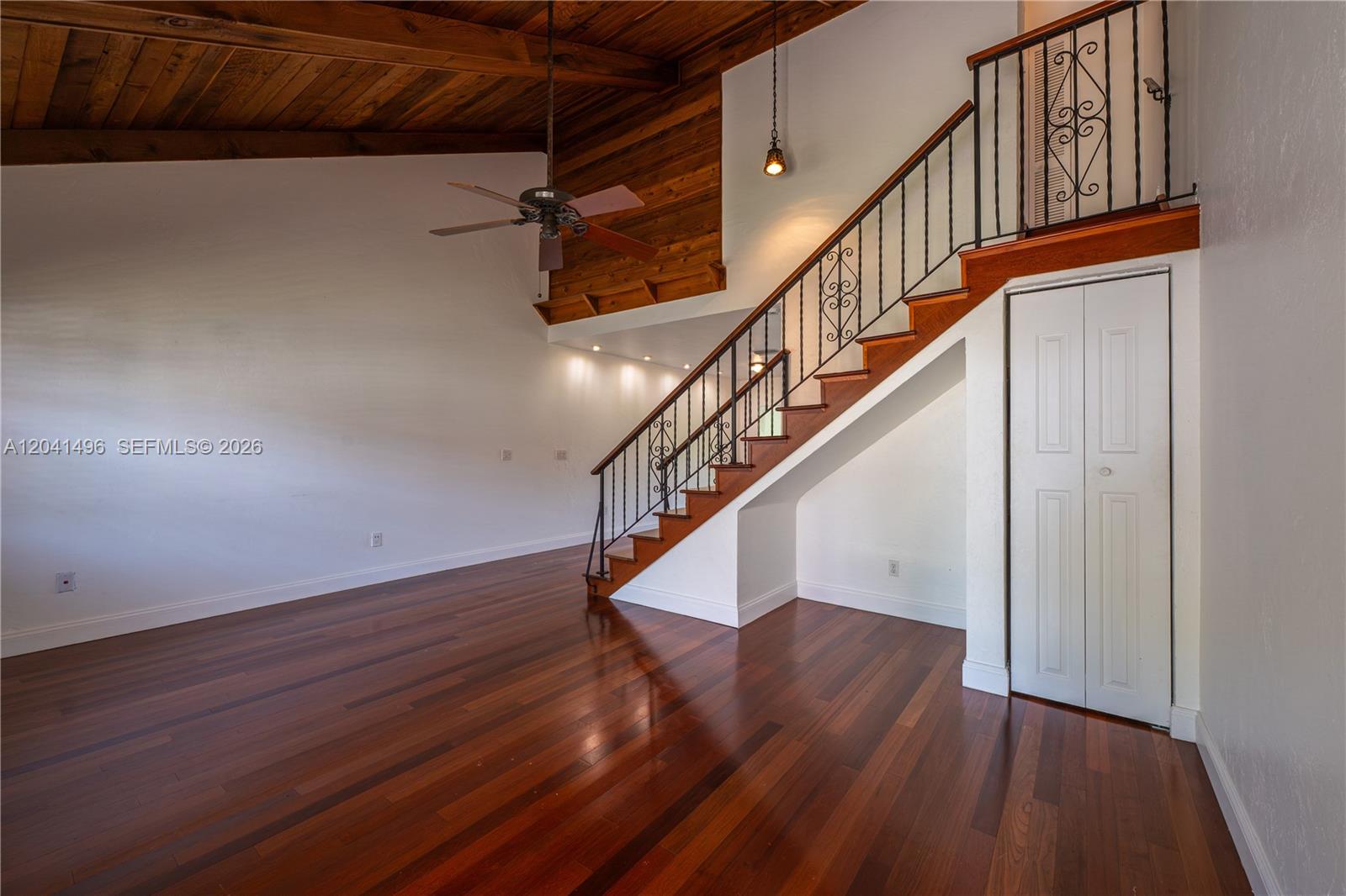 A living room features hardwood floors, a vaulted wood-paneled ceiling, and a staircase with railing — 2133 N 14th Ave, Hollywood FL 33020, HOLLYWOOD, FL
