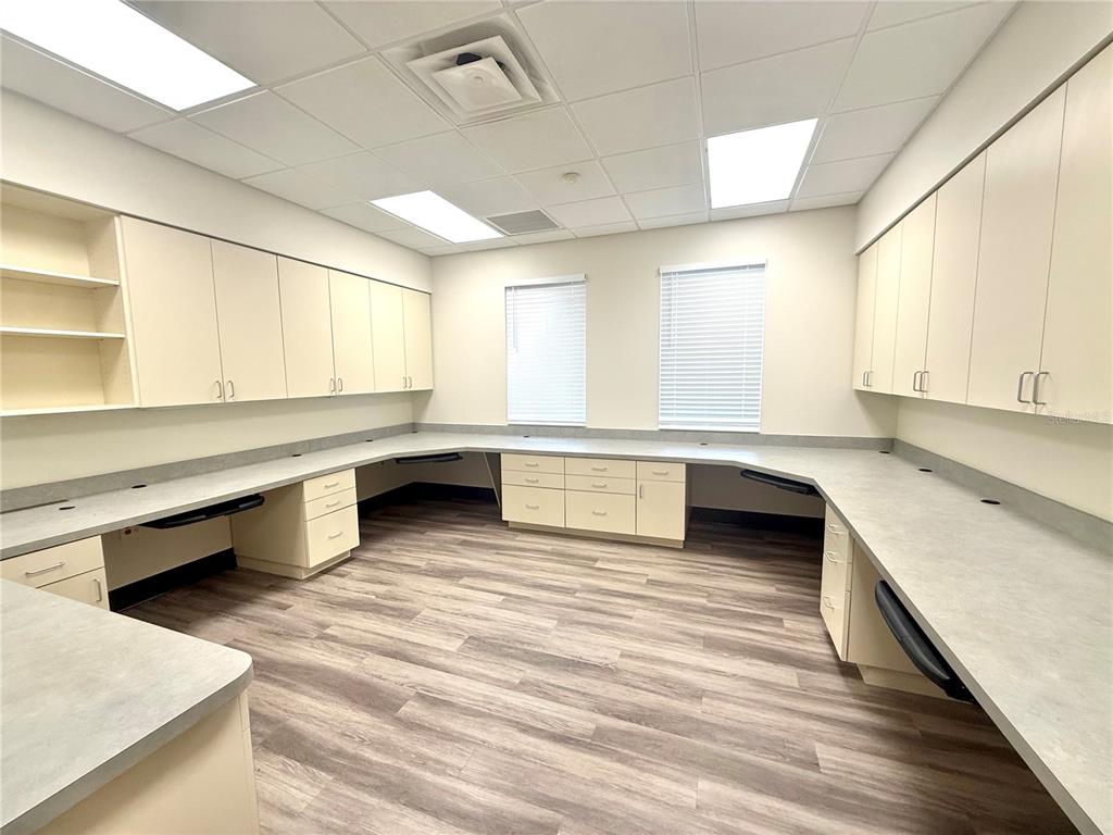 An office or workspace features light-colored cabinetry, a wrap-around countertop, and wood-look flooring — 5935 WEBB ROAD, TAMPA, FL