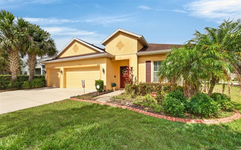 A yellow single-story house with a two-car garage and palm trees in the front yard — 12607 GENEVA GLADE DRIVE, RIVERVIEW, FL