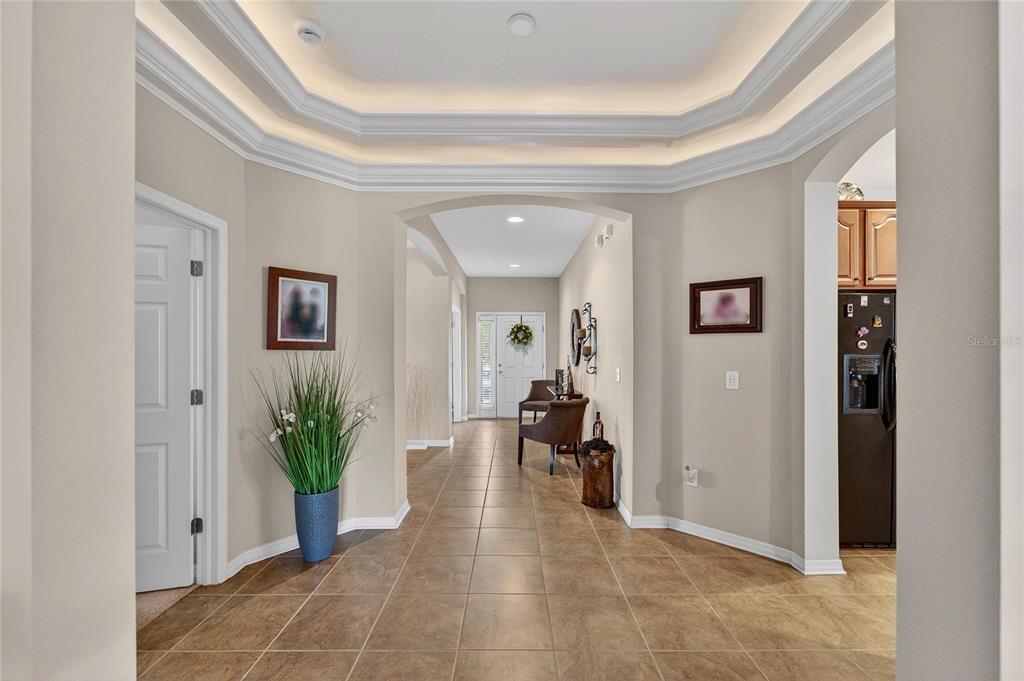 A tiled entryway features a tray ceiling with recessed lighting and an arched hallway — 12607 GENEVA GLADE DRIVE, RIVERVIEW, FL