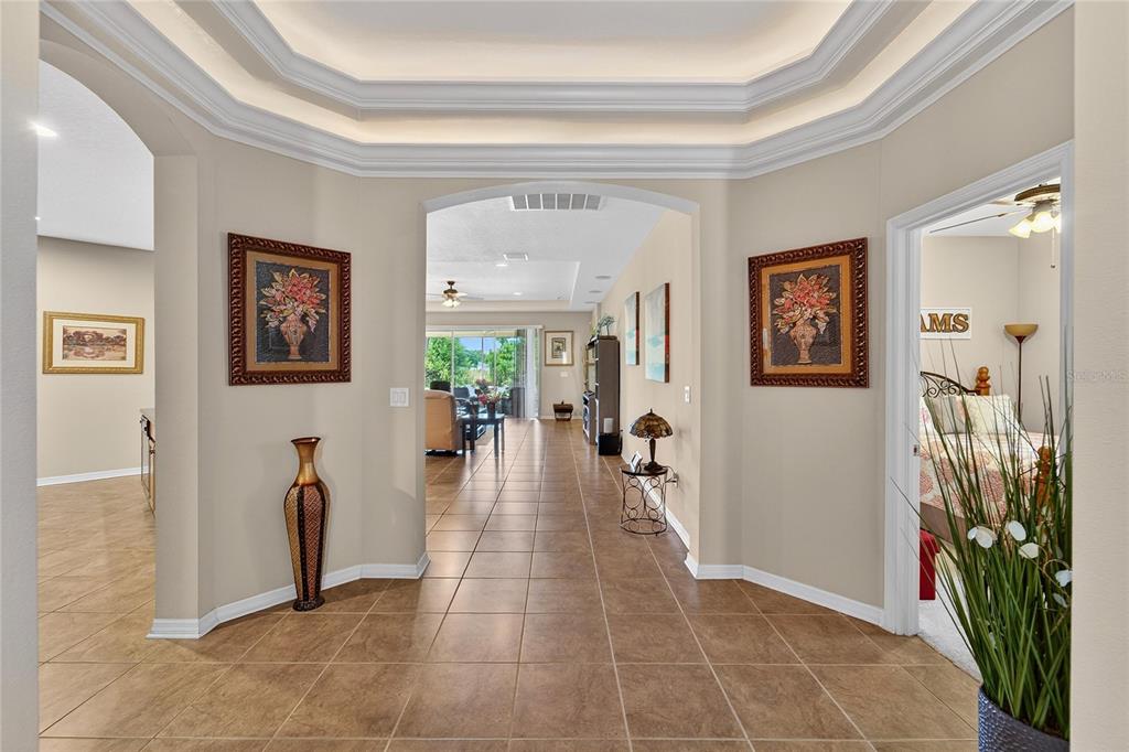 A tiled foyer leads into a living area with a tray ceiling and arched openings — 12607 GENEVA GLADE DRIVE, RIVERVIEW, FL