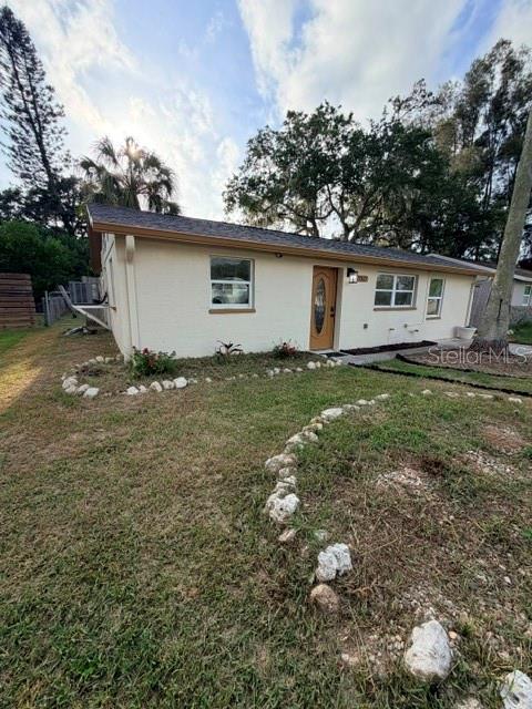 A single-story house with light-colored siding and a front door sits on a grassy lot — 7317 OELSNER STREET, NEW PORT RICHEY, FL