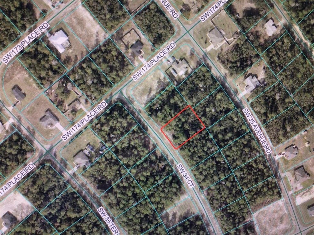This is an aerial map view showing a vacant, wooded residential lot outlined in red — 0 SW 34 COURT, OCALA, FL