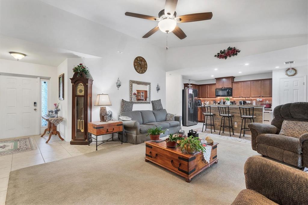 A living room with a ceiling fan, grandfather clock, and an open kitchen with bar seating — 1826 SW TRAFALGAR PARKWAY, CAPE CORAL, FL