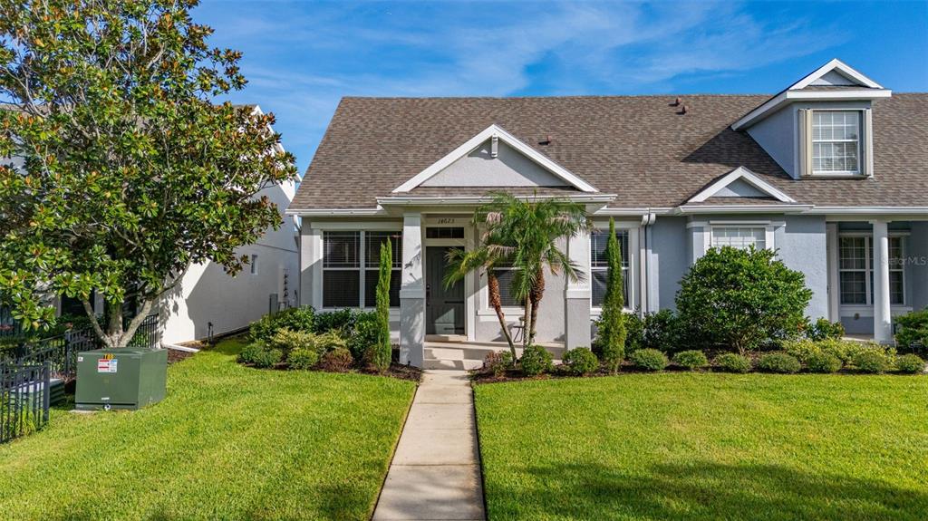 A single-story house with a gray exterior, a front porch, and a landscaped front yard — 14623 SWEET ACACIA DRIVE, ORLANDO, FL