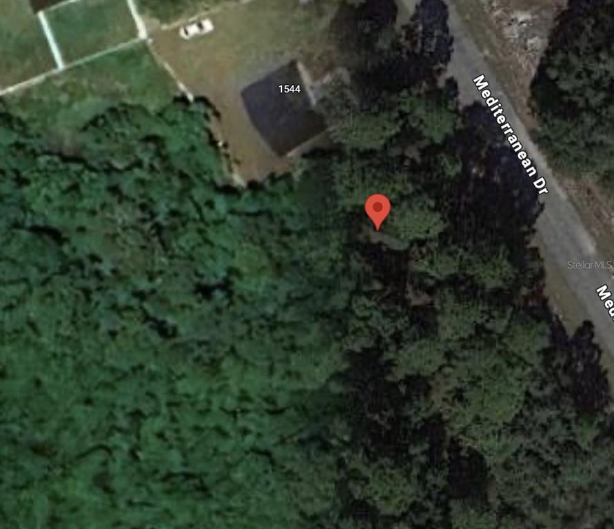 This aerial map view shows a wooded lot located next to a house and road — 1548 MEDITERRANEAN DRIVE, KISSIMMEE, FL