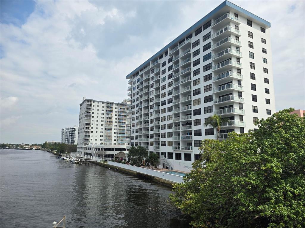 A tall white apartment building stands beside a river with boats docked nearby — 1401 N Riverside Drive N # 307, Pompano Beach FL 33062, POMPANO BEACH, FL