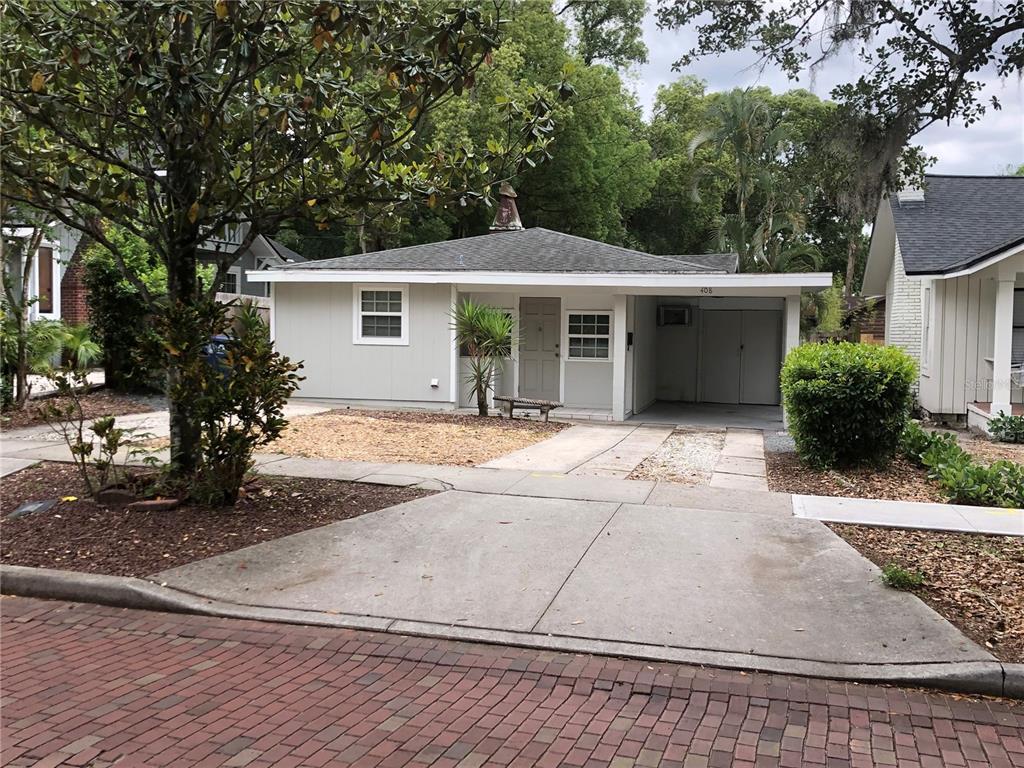 A single-story house with a light gray exterior, a carport, and a brick street — 408 HOLT AVENUE, WINTER PARK, FL