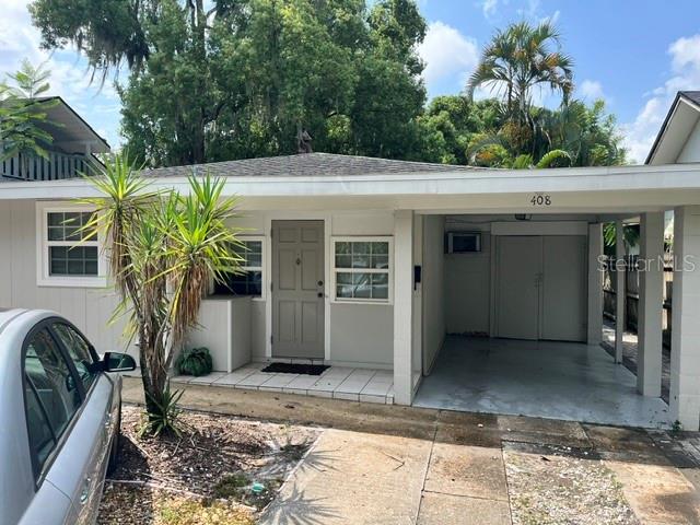 A single-story house with a carport, a gray front door, and a small palm tree — 408 HOLT AVENUE, WINTER PARK, FL