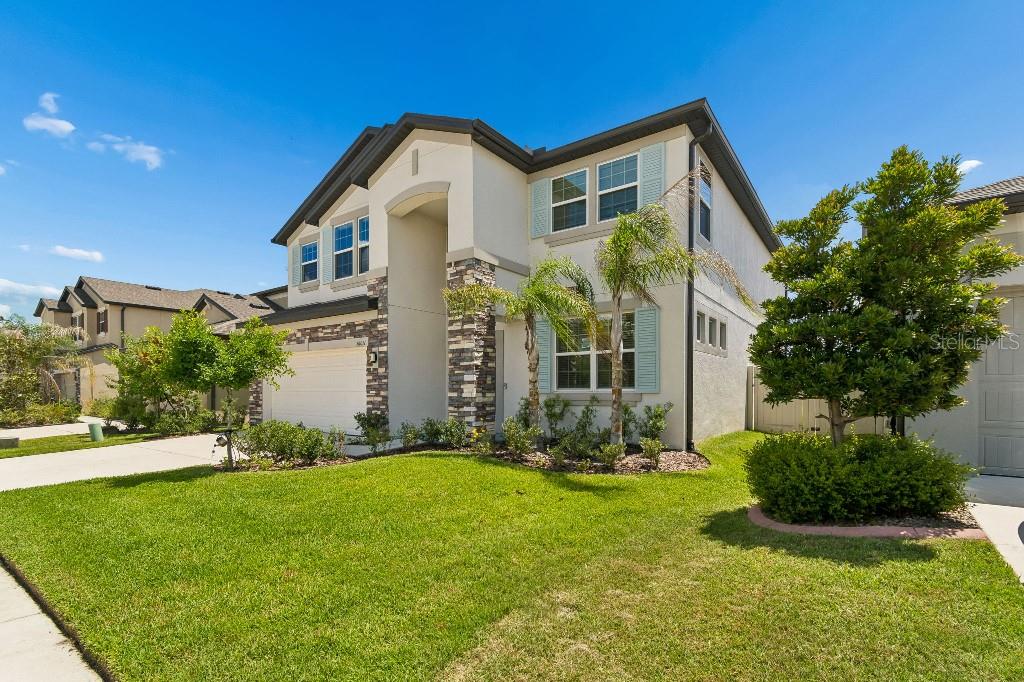 A two-story suburban house with a stucco exterior, stone accents, and a two-car garage — 16011 SONOMA GROVE CIRCLE, TAMPA, FL